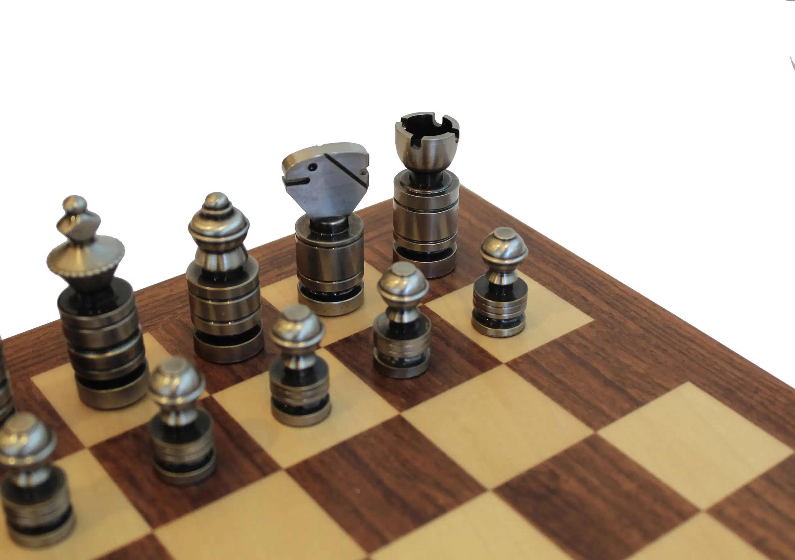 Détail des pièces d'échecs contemporaines couleur argent sombre posées sur l'échiquier en acajou et érable