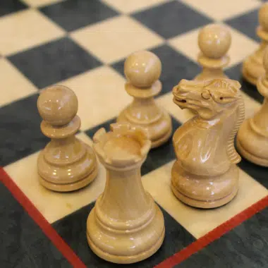 Détail du Cavalier et de la Tour d'échecs en buis laqué ivoire sur les cases de l'échiquier